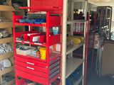 a red shelf with tools in it in a garage