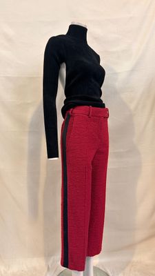 black turtle neck sweater and red pants on a mannequin stand