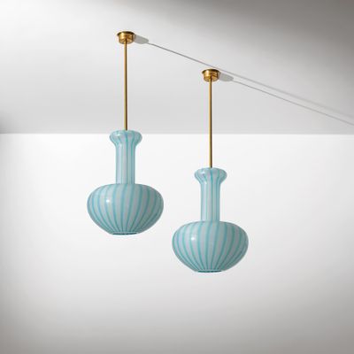 deux vases en verre bleu suspendus au plafond dans une pièce blanche