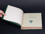 someone is holding a book open on a black surface
