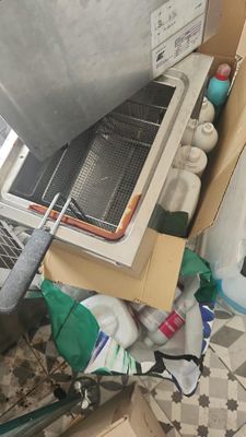 a box full of items sitting on the floor next to a stove