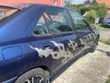 a blue car that has a cow print on the side of it