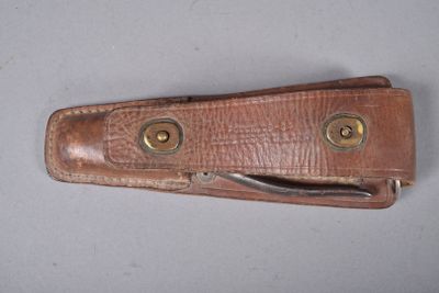un étui en cuir marron orné de deux boutons en laiton
