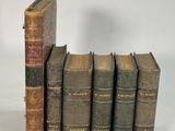 plusieurs vieux livres empilés sur une surface blanche