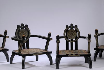 three wooden chairs with black and gold designs on them against a white background