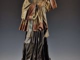 une vieille statue représentant un homme tenant une épée et vêtu d'une robe