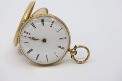 a gold pocket watch with roman numerals on it