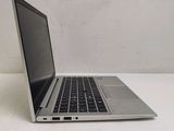a silver laptop computer sitting on a white surface