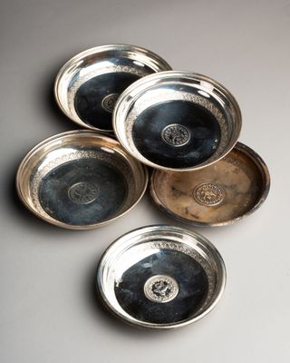 six bols plaqués argent posés sur une table avec un fond blanc