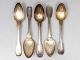 six spoons are lined up in a row on a white surface