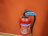 a fire extinguisor on the floor next to a toilet