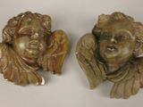 two statues of angels on a white surface with a white background
