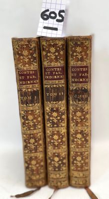 three old books sitting on top of each other on a white surface