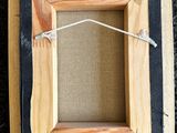 a close up of a picture frame with a string attached to it