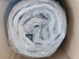 un rouleau de plastique emballé dans du film alimentaire, dans une boîte en carton
