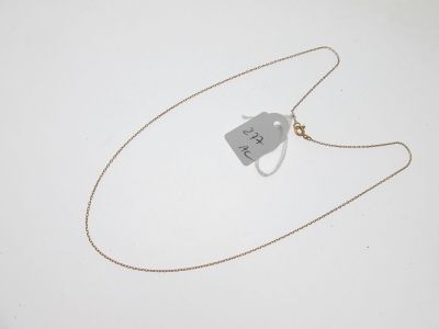 un collier muni d'une étiquette, posé sur une surface blanche