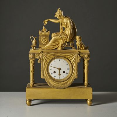 une horloge en or surmontée d'une statue