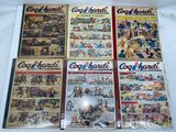 several comics are on display on a table in front of a white background