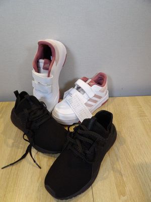 two pairs of shoes that are on a wooden floor