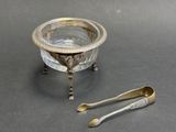 a silver plate with a spoon and spoon rest on a table