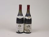 two bottles of wine sitting next to each other on a white surface