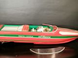 a red and green speed boat on a black surface