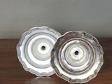 two silver candlesticks sitting on a wooden table