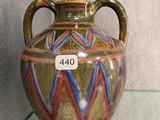 a vase that is on display on a glass shelf