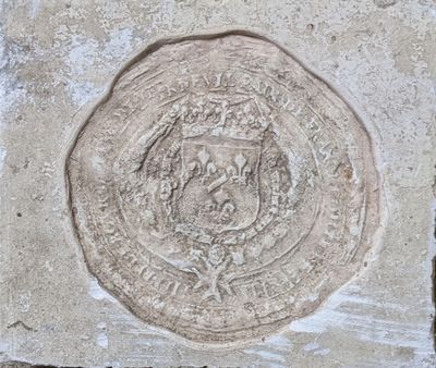 une plaque en pierre sur laquelle figure un blason