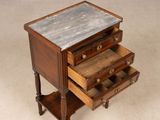 a small wooden table with three drawers on it