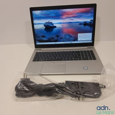 un ordinateur portable posé sur une table avec un chargeur