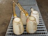 trois vases posés sur une grille métallique dans une pièce