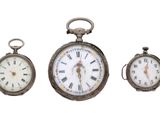 trois horloges posées les unes à côté des autres sur une surface blanche