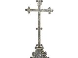 une image représentant une croix en argent posée sur un rocher