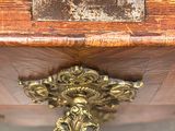 a close up of a wooden table with a gold decoration