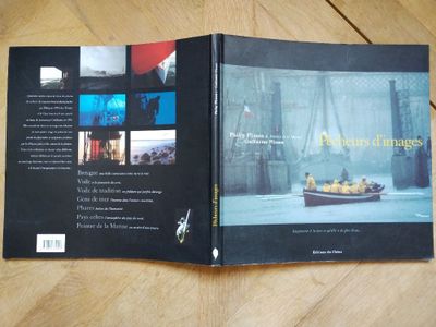 le livre est ouvert sur une table en bois, à côté d'une photo de voiture