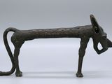 an old bronze statue of a dog with a bell on it ' s head