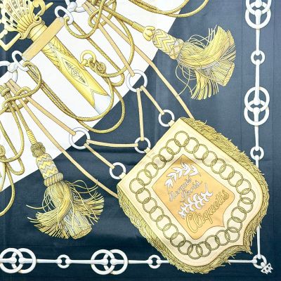 une photo d'une écharpe sur laquelle figurent une couronne et un sac à main