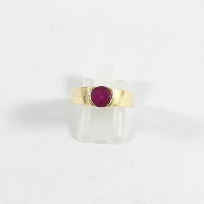 gros plan d'une bague en or avec une pierre en rubis