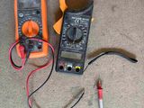 an orange and black multimeter sitting on top of a carpet next to a red and black wire