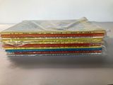 several children ' s books stacked on top of each other on a table
