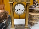 a gold clock sitting on top of a table next to other items