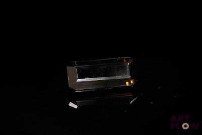 une boîte en verre posée sur une surface noire