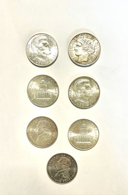 six different coins are arranged in a row on a white surface
