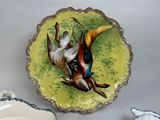 a plate with two birds painted on it and a bowl with a saucer