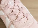 pink sneakers with white laces are on a wooden surface
