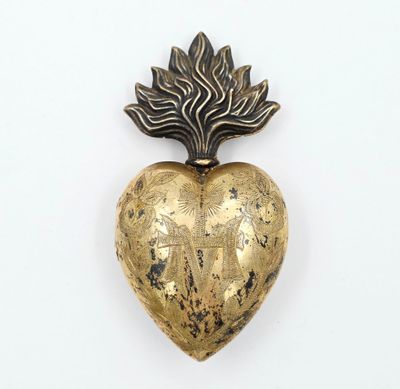 une broche en or en forme de cœur ornée d'une feuille