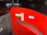 a close up of a red trash can with a sticker on it