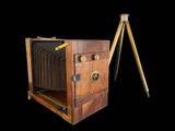 an old wooden camera with a tripod on a tripod stand