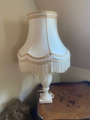 une petite table sur laquelle se trouve une lampe, à côté d'un ours en peluche